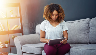 Buy stock photo Shot of a young businesswoman using a digital tablet on the sofa in a modern office