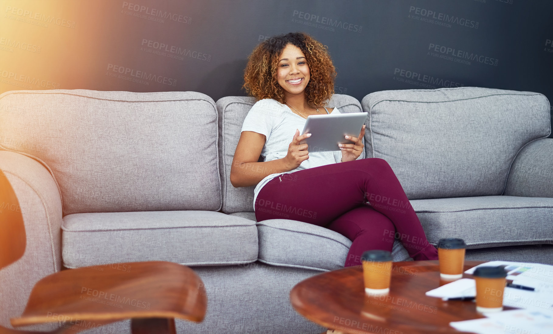 Buy stock photo Portrait of a young businesswoman using a digital tablet on the sofa in a modern office