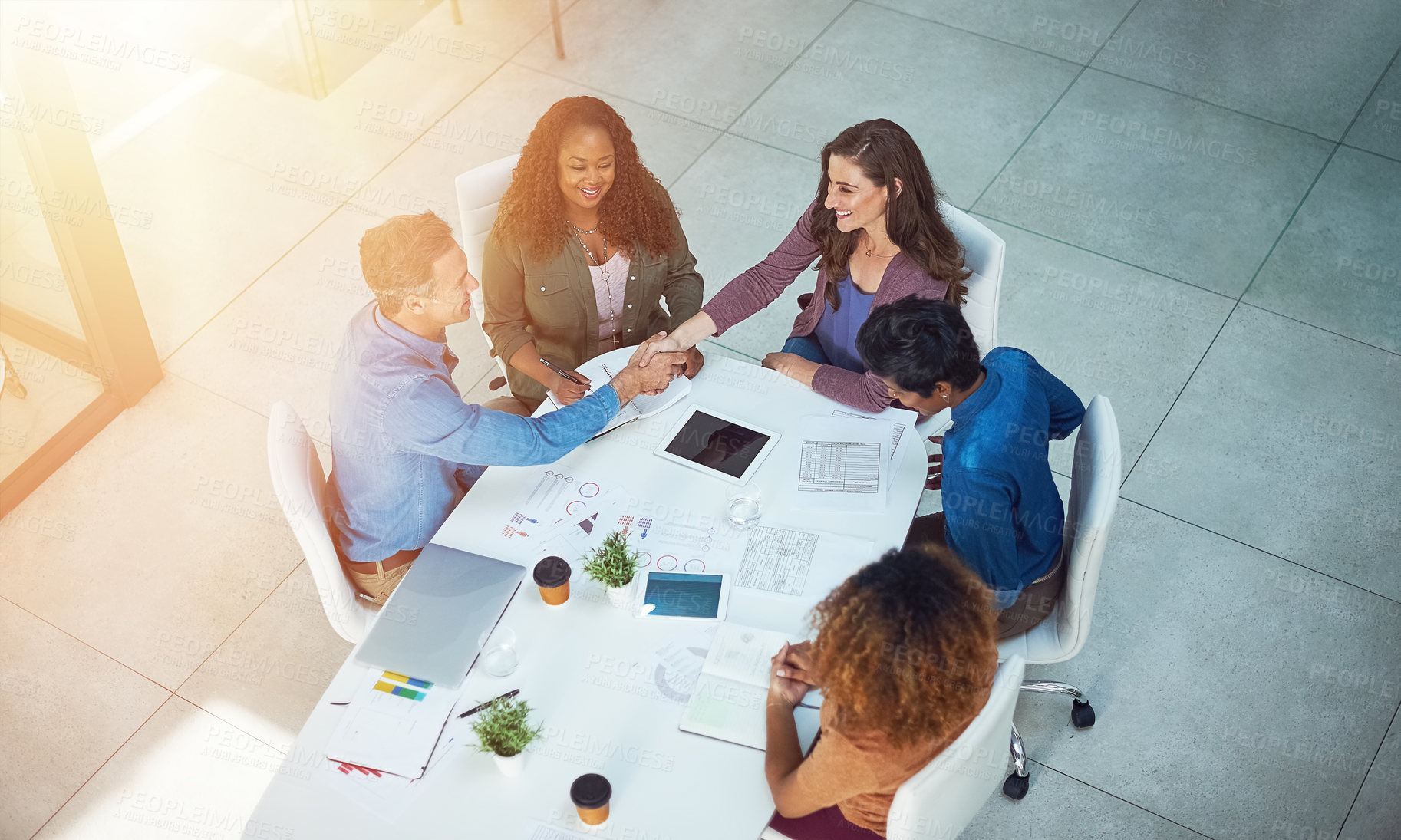 Buy stock photo High angle shot of two designers shaking hands during a meeting