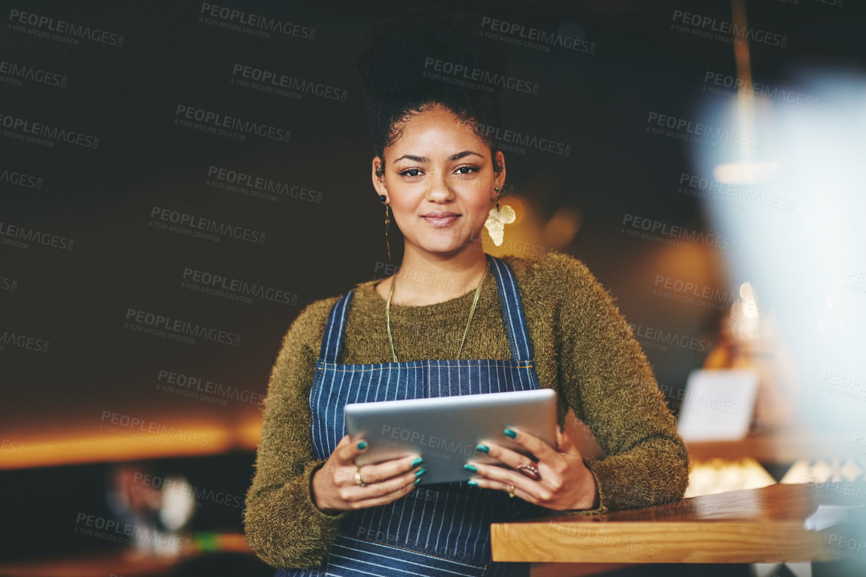 Buy stock photo Shot of a young woman using a  digital tablet while working at a coffee shop