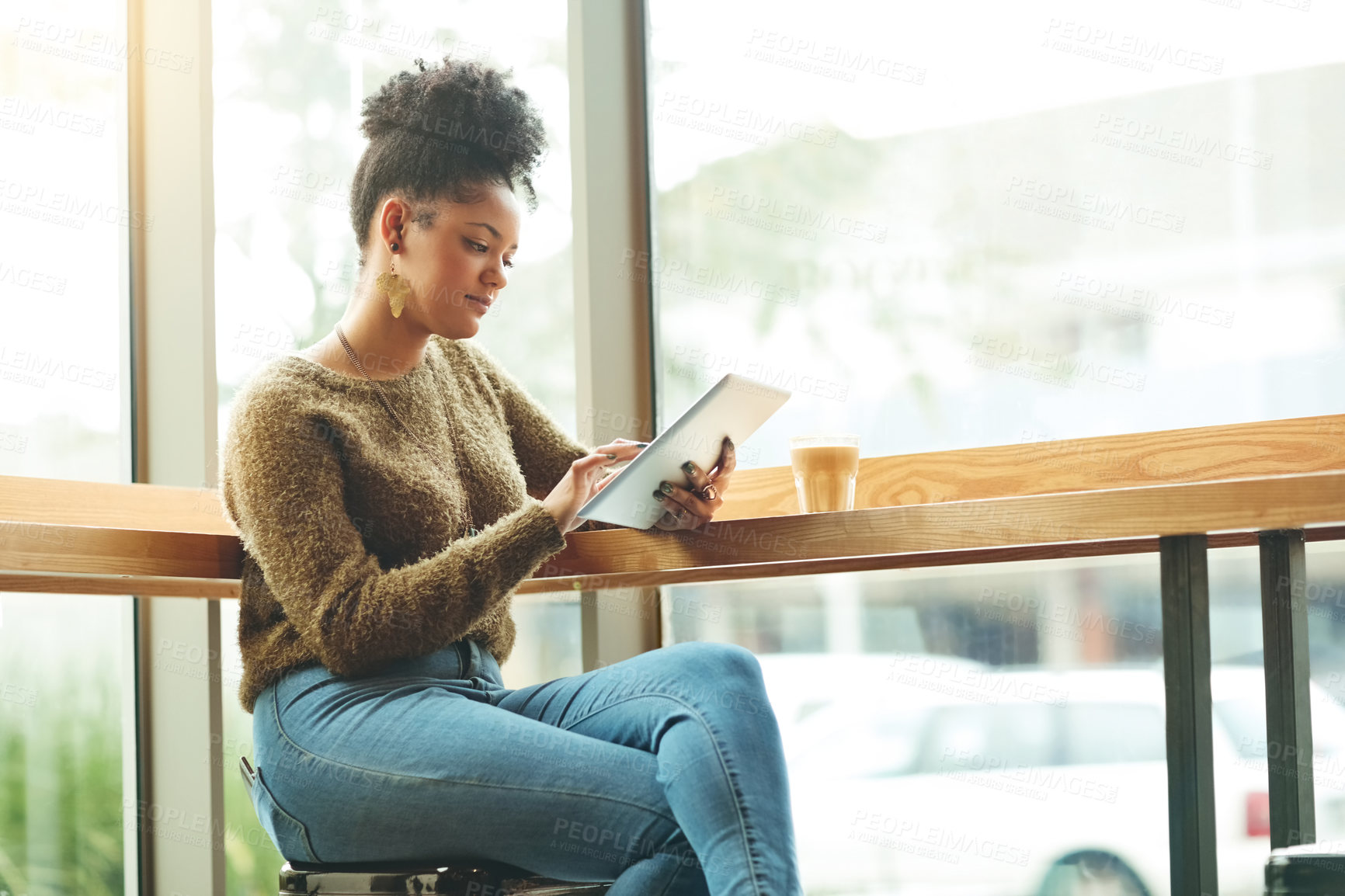 Buy stock photo Cropped shot of an attractive young woman using a digital tablet in a cafe