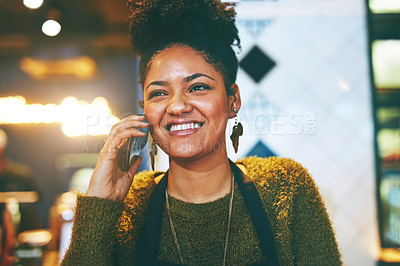 Buy stock photo Shot of a young woman using a phone while working at a coffee shop