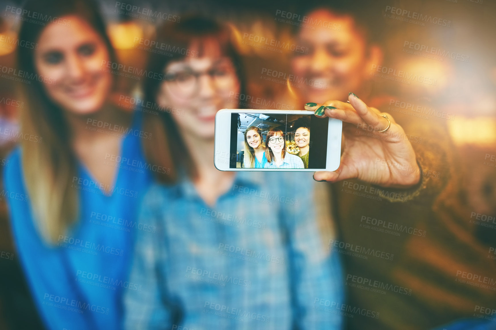 Buy stock photo Shot of three young friends taking a selfie together in a cafe