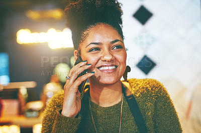 Buy stock photo Shot of a young business owner talking on a cellphone in her cafe