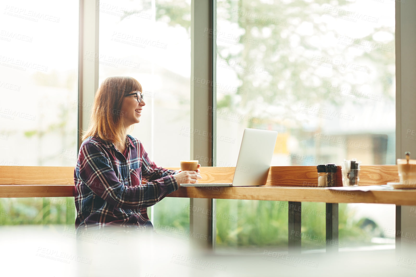 Buy stock photo Cropped shot of an attractive young woman using her laptop in a cafe