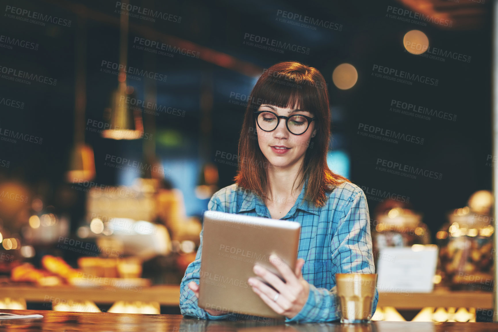 Buy stock photo Shot of an attractive young woman using a digital tablet in a cafe