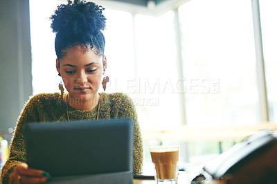 Buy stock photo Cropped shot of an attractive young woman using a digital tablet in a cafe