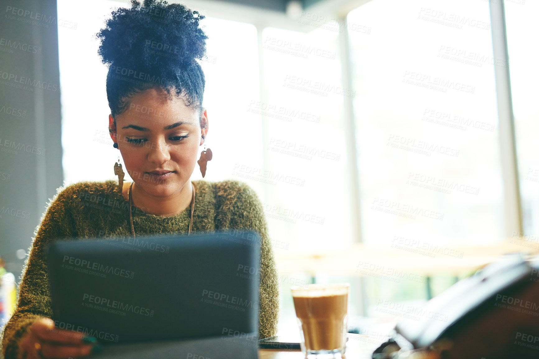 Buy stock photo Cropped shot of an attractive young woman using a digital tablet in a cafe