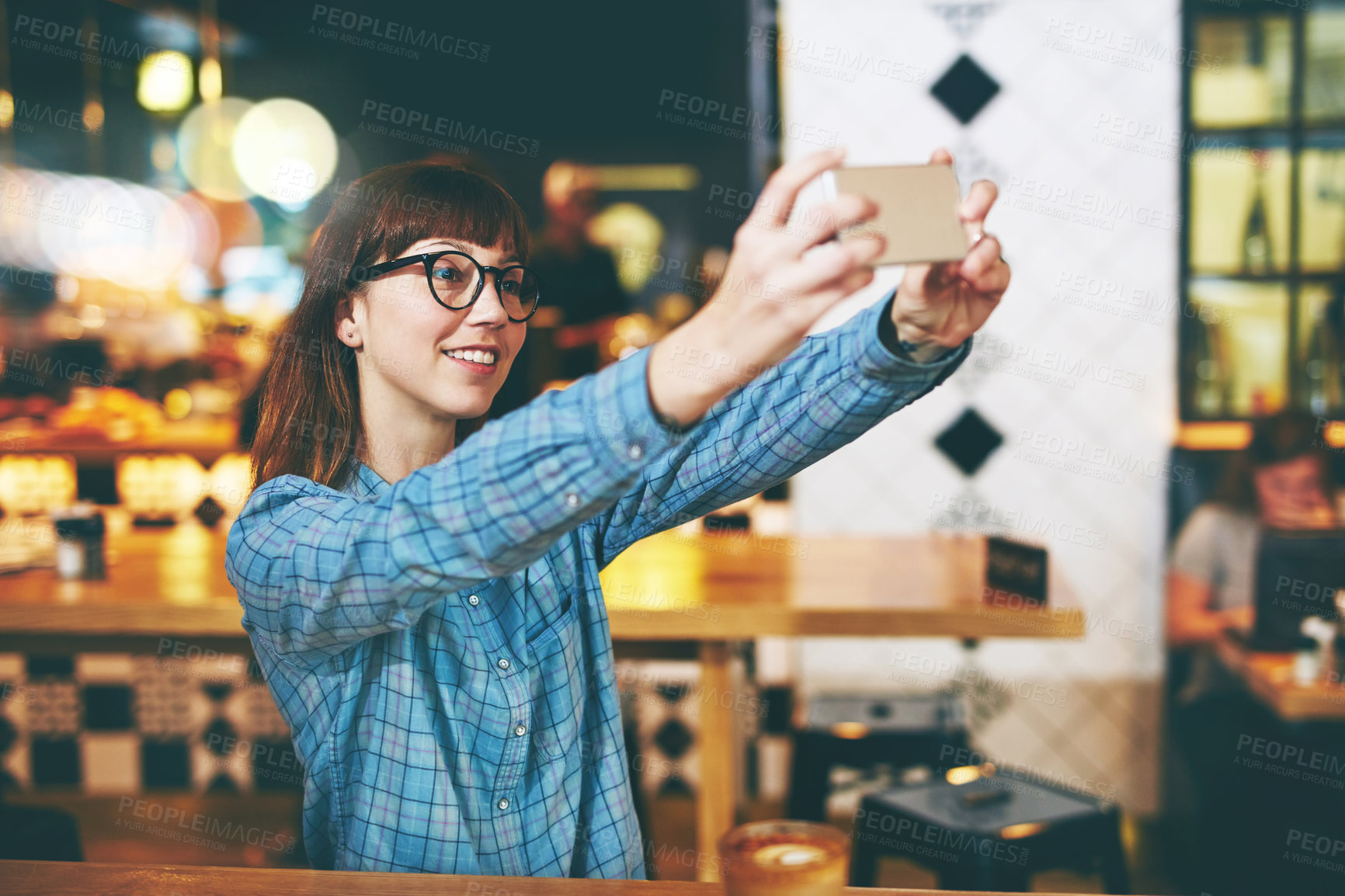Buy stock photo Shot of an attractive young woman taking a selfie in a cafe