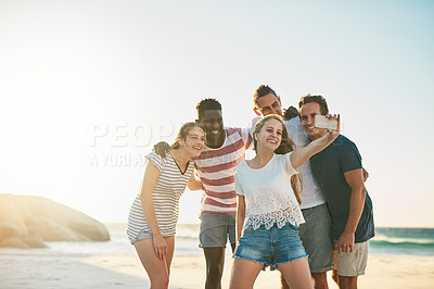 Buy stock photo Shot of a happy group of friends taking selfies together at the beach