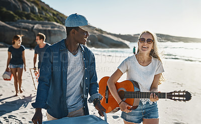 Buy stock photo Shot of a group of young friends walking on the beach on a sunny day