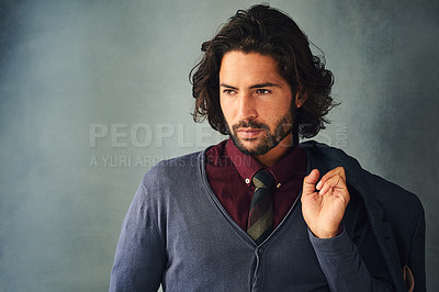 Buy stock photo Studio shot of a stylishly dressed handsome young man with his jacket over his shoulder