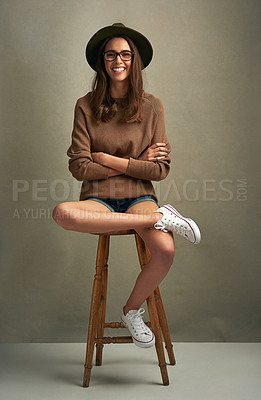 Buy stock photo Shot of a beautiful young woman sitting against a brown background