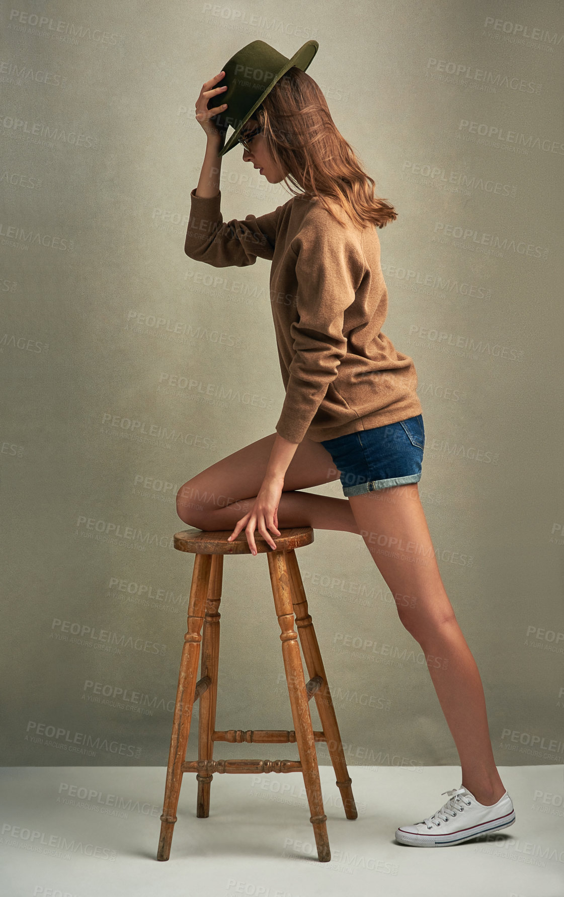 Buy stock photo Woman, hat and chair in studio for profile, theater audition and performance by studio background. Actress, fedora and position on stool for portfolio, rehearsal and inspiration for stage presence