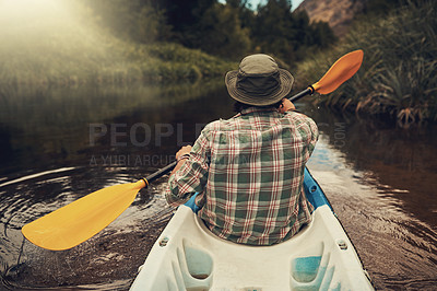 Buy stock photo Rearview shot of a young man going for a canoe ride on the lake