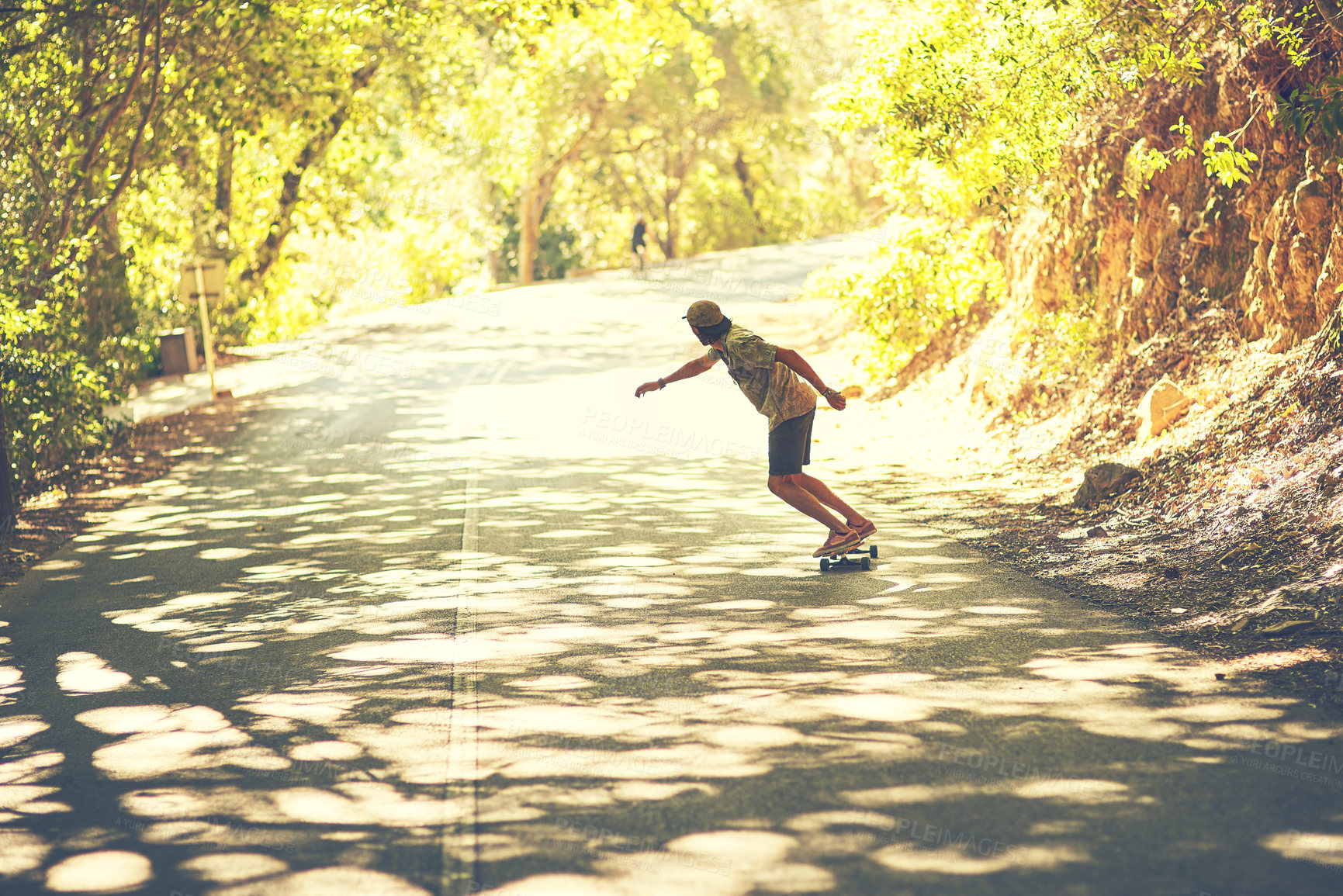 Buy stock photo Rearview shot of a young man longboarding in the street