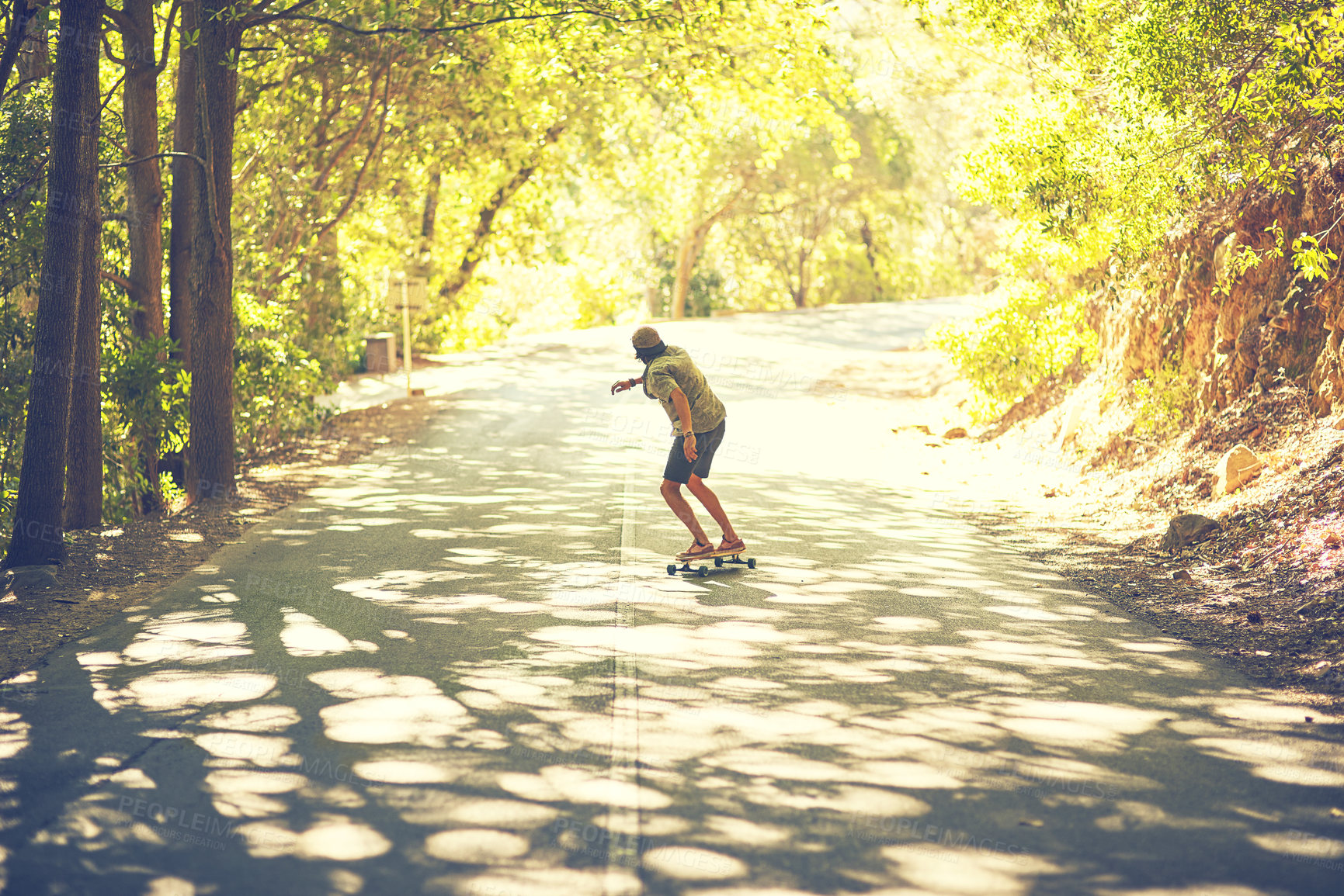 Buy stock photo Rearview shot of a young man longboarding in the street