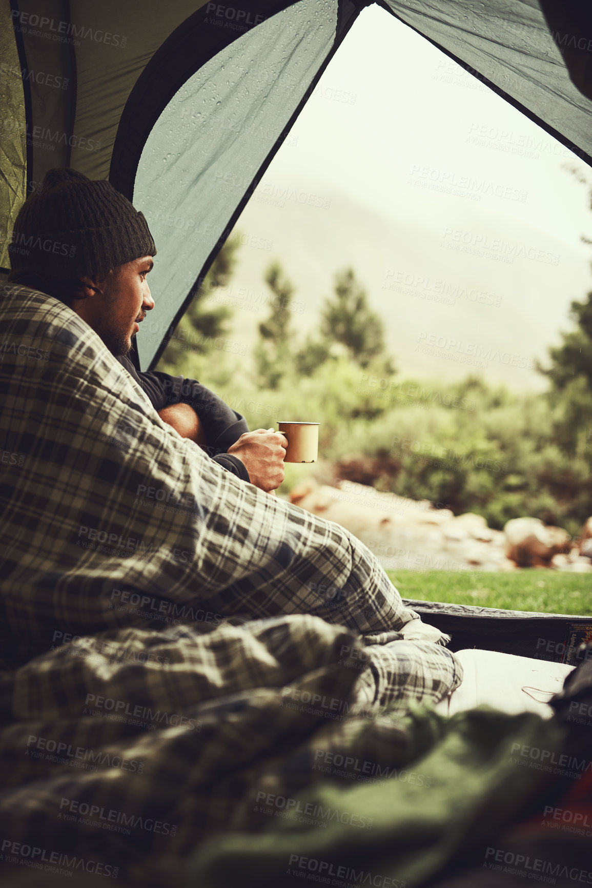 Buy stock photo Cropped shot of young man sitting in his tent at a campsite