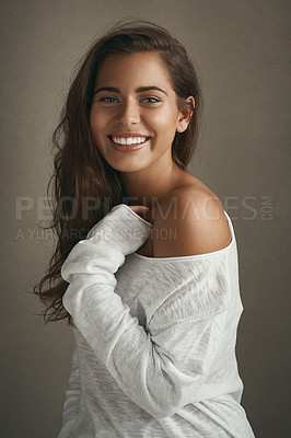 Buy stock photo Portrait of a beautiful young woman smiling against a brown background in studio