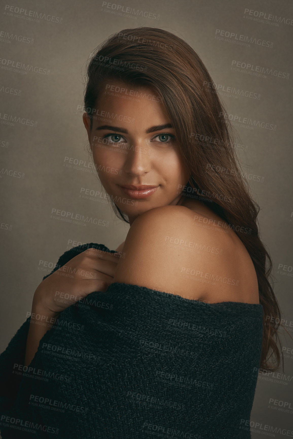 Buy stock photo Portrait of a beautiful young woman smiling against a brown background in studio