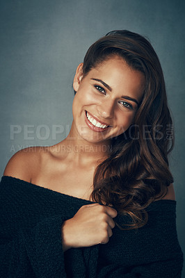 Buy stock photo Portrait of a beautiful young woman smiling against a gray background in studio
