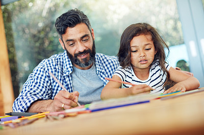 Buy stock photo Cropped shot of a father and daughter colouring in together at home