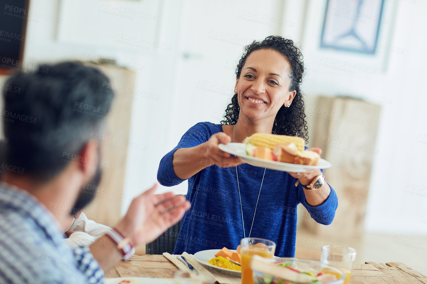 Buy stock photo Shot of a happy family gathered around their table for a meal