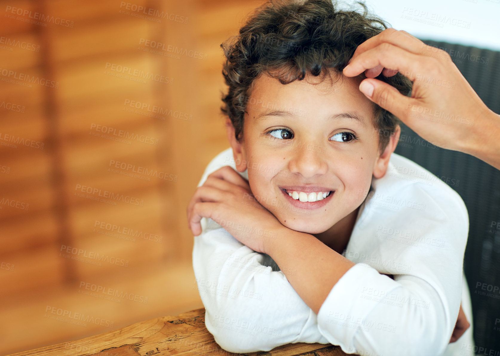 Buy stock photo Shot of an unidentifiable mother touching her adorable little boy's hair at home