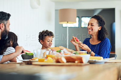 Buy stock photo Shot of a happy family gathered around their table for a meal