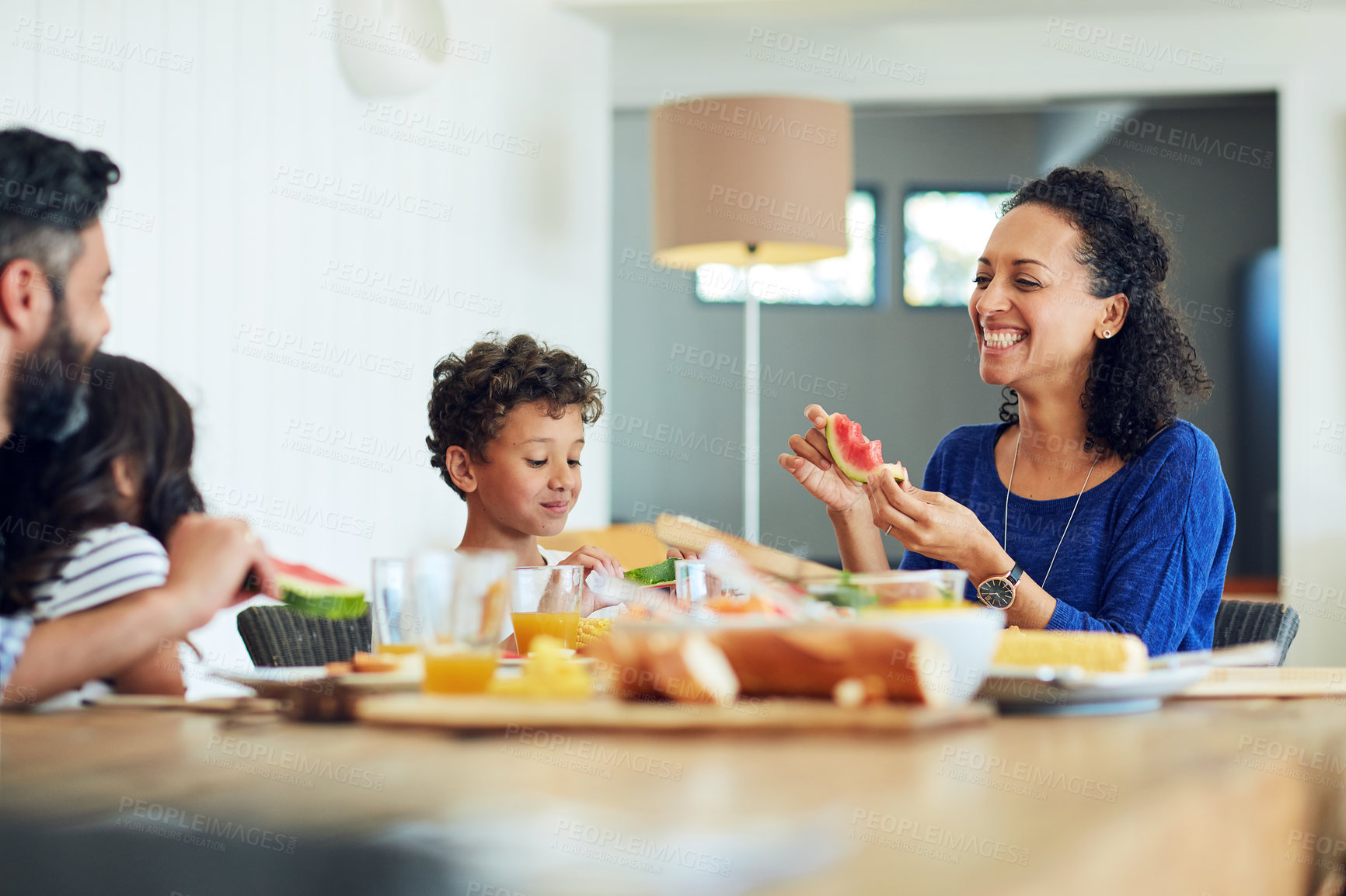 Buy stock photo Shot of a happy family gathered around their table for a meal