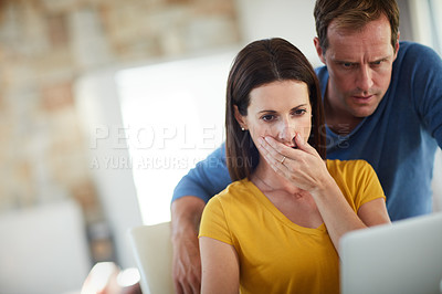 Buy stock photo Cropped shot of a mature couple looking shocked while using a laptop together at home