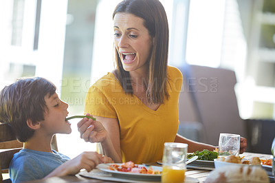 Buy stock photo Cropped shot of a mother and her little son enjoying a meal together at home