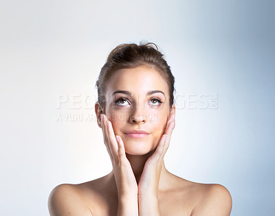 Buy stock photo Studio shot of a beautiful young woman with her hands on her cheeks