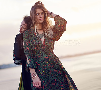 Buy stock photo Shot of two young women spending the day at the beach at sunset