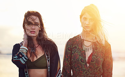 Buy stock photo Shot of two young women spending the day at the beach at sunset