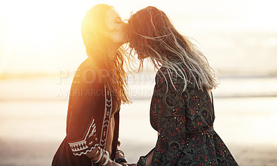 Buy stock photo Shot of two young women spending the day at the beach at sunset