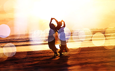 Buy stock photo Shot of two young women spending the day at the beach at sunset