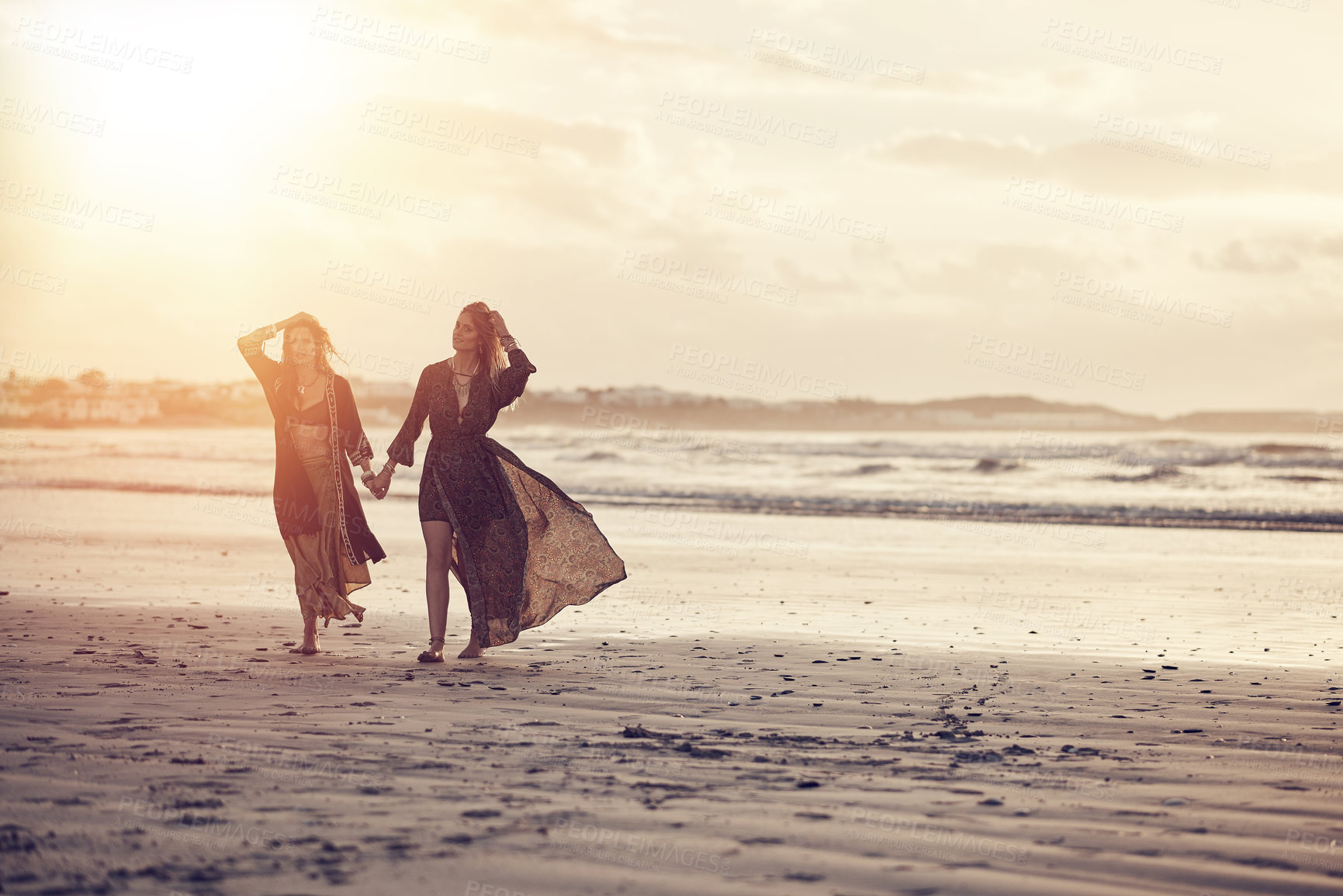 Buy stock photo Friends, women and holding hands on coast for vacation, summer travel and abroad tourism for bonding. Support, beach holiday and people with flare for connection, walking space and getaway in Morocco