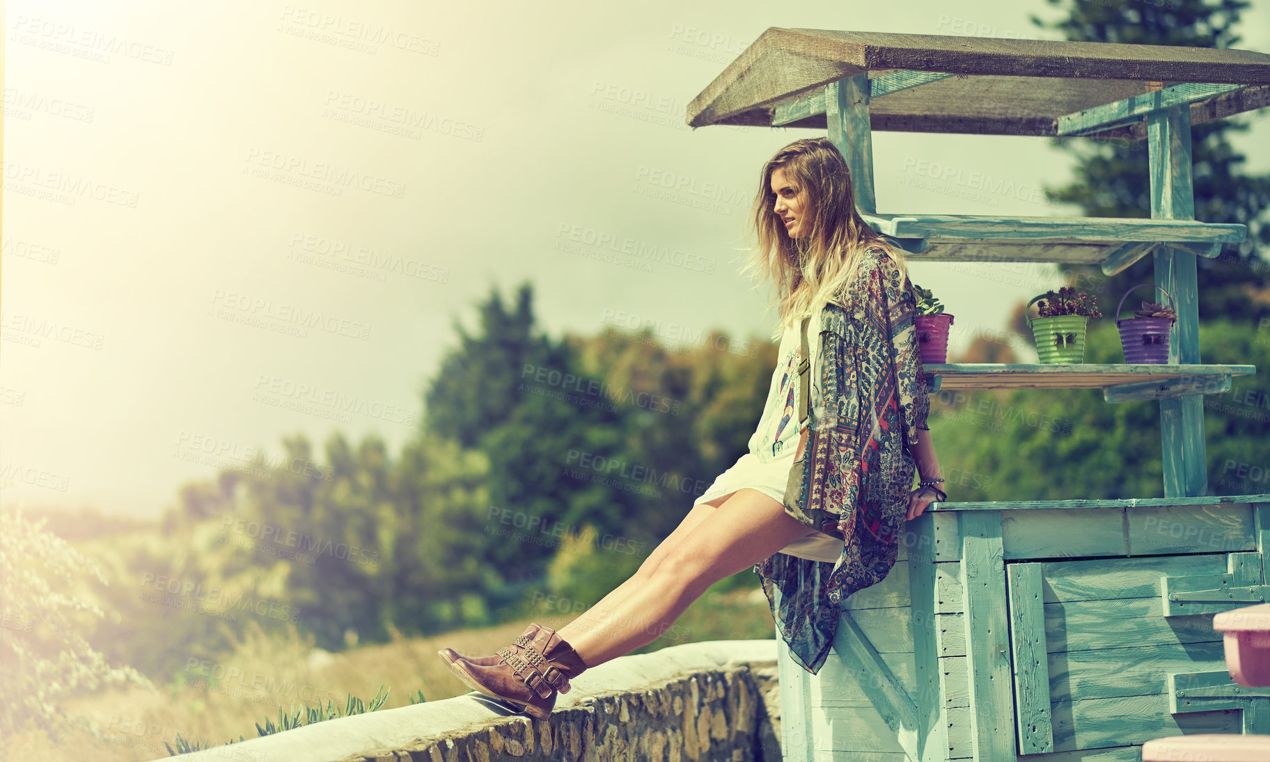 Buy stock photo Shot of a fashionable young woman posing outside on a sunny day