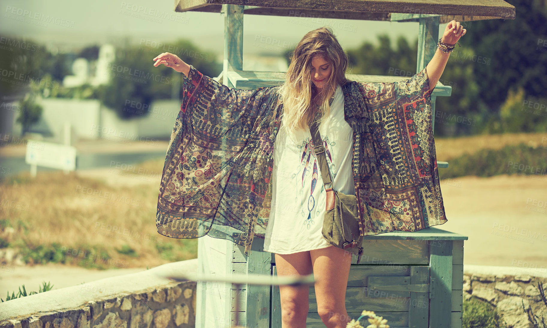 Buy stock photo Shot of a free spirited young woman enjoying the sunshine outside