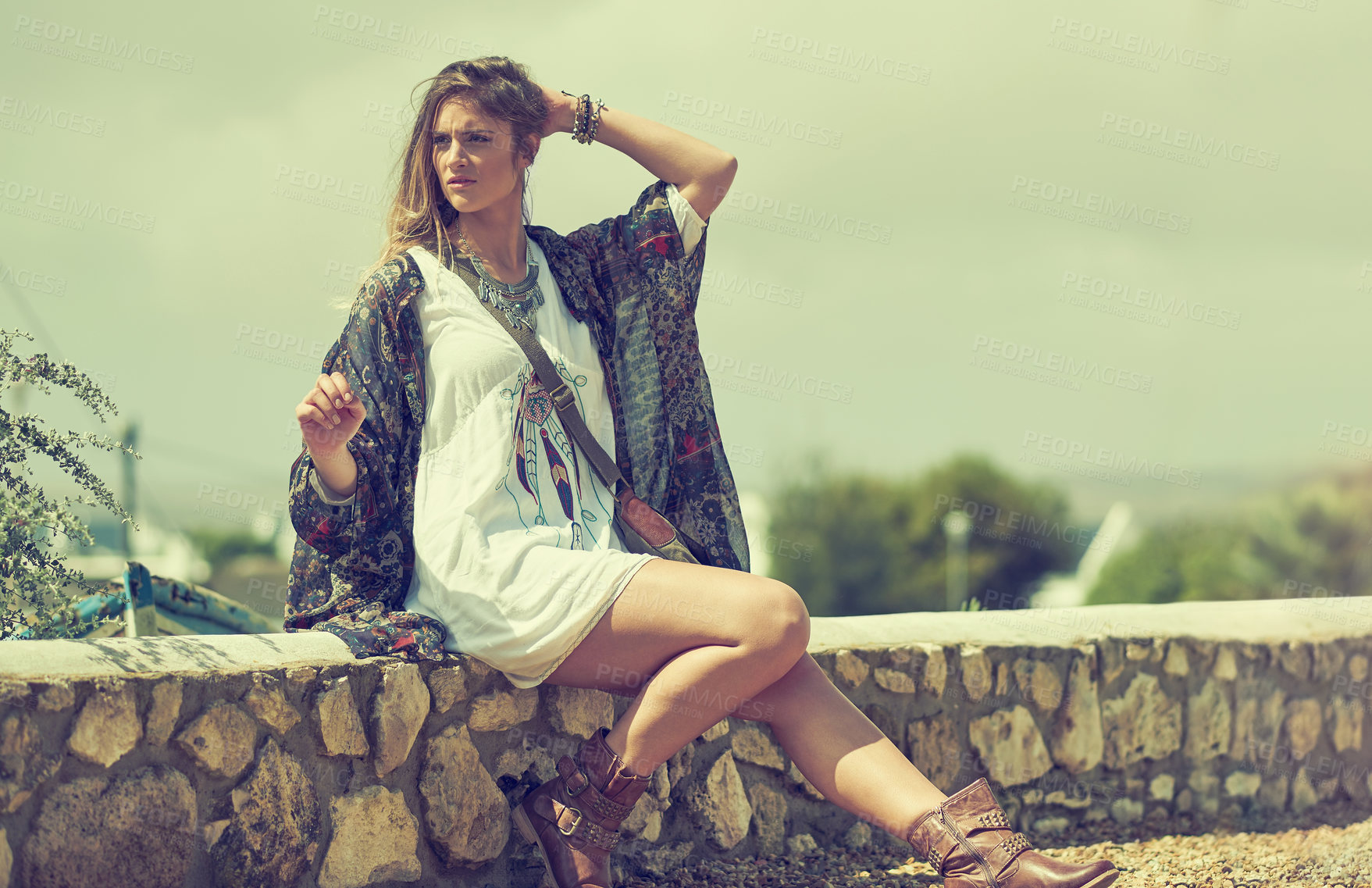 Buy stock photo Shot of a fashionable young woman posing outside on a sunny day