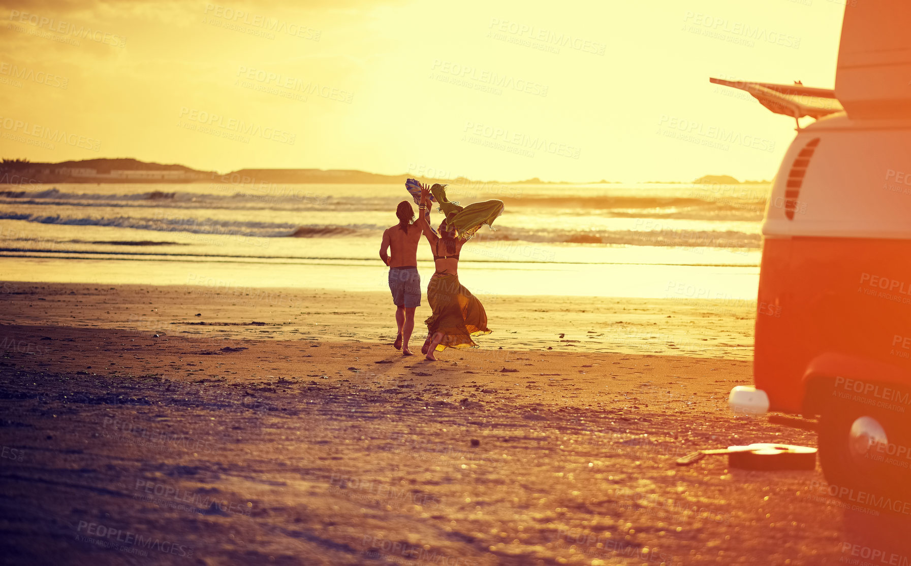 Buy stock photo Rearview shot of a young couple running towards the water on a beach