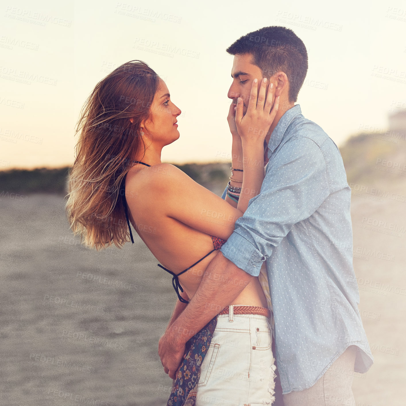 Buy stock photo Shot of an affectionate young couple at the beach