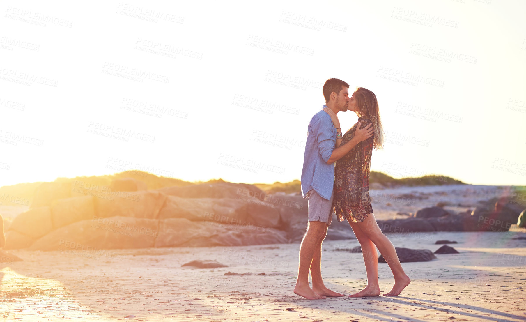 Buy stock photo Shot of an affectionate young couple at the beach