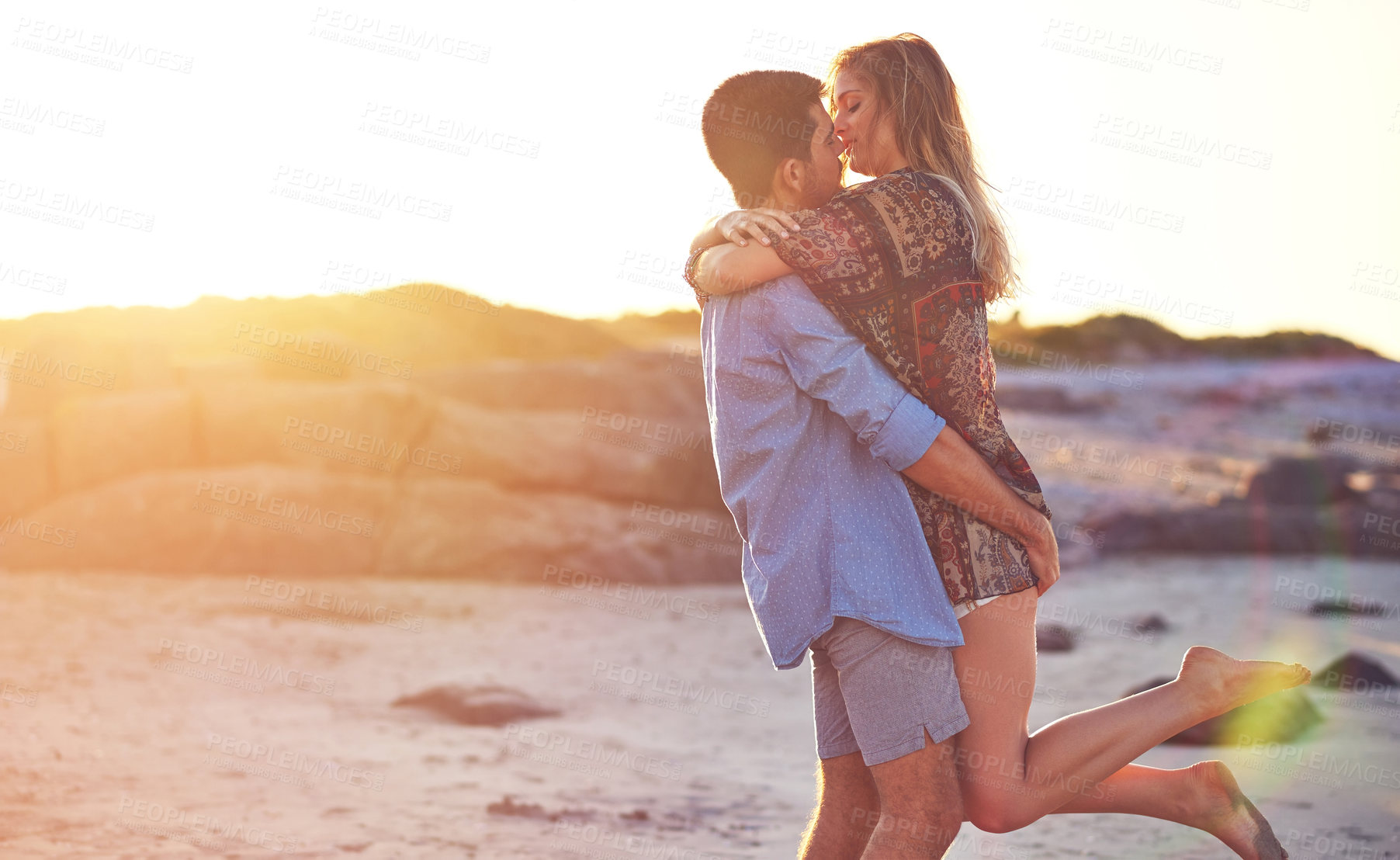 Buy stock photo Shot of an affectionate young couple at the beach