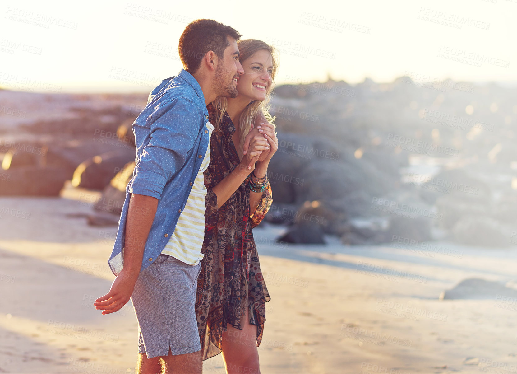 Buy stock photo Shot of a happy young couple going for a walk along the beach