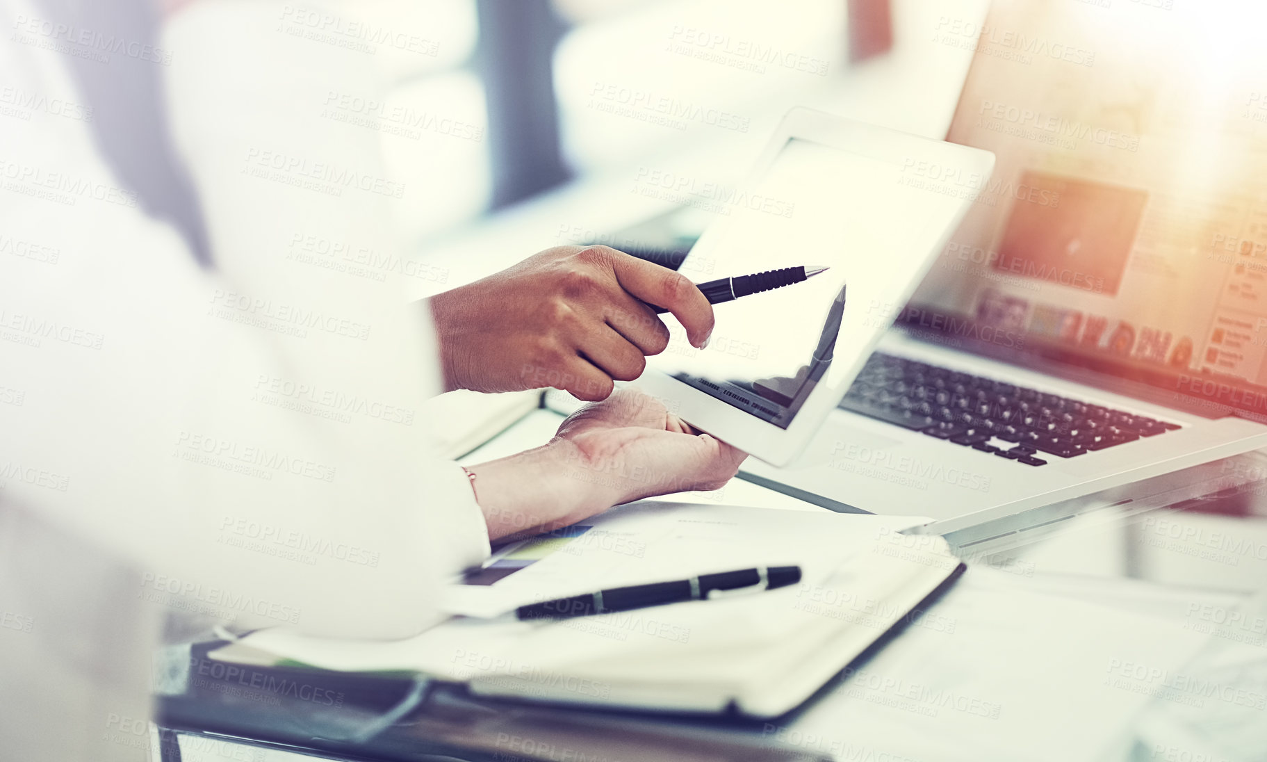 Buy stock photo Cropped shot of two colleagues using a digital tablet together during a collaboration at work