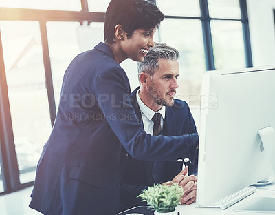 Buy stock photo Shot of a businesswoman and businessman using a computer together at work