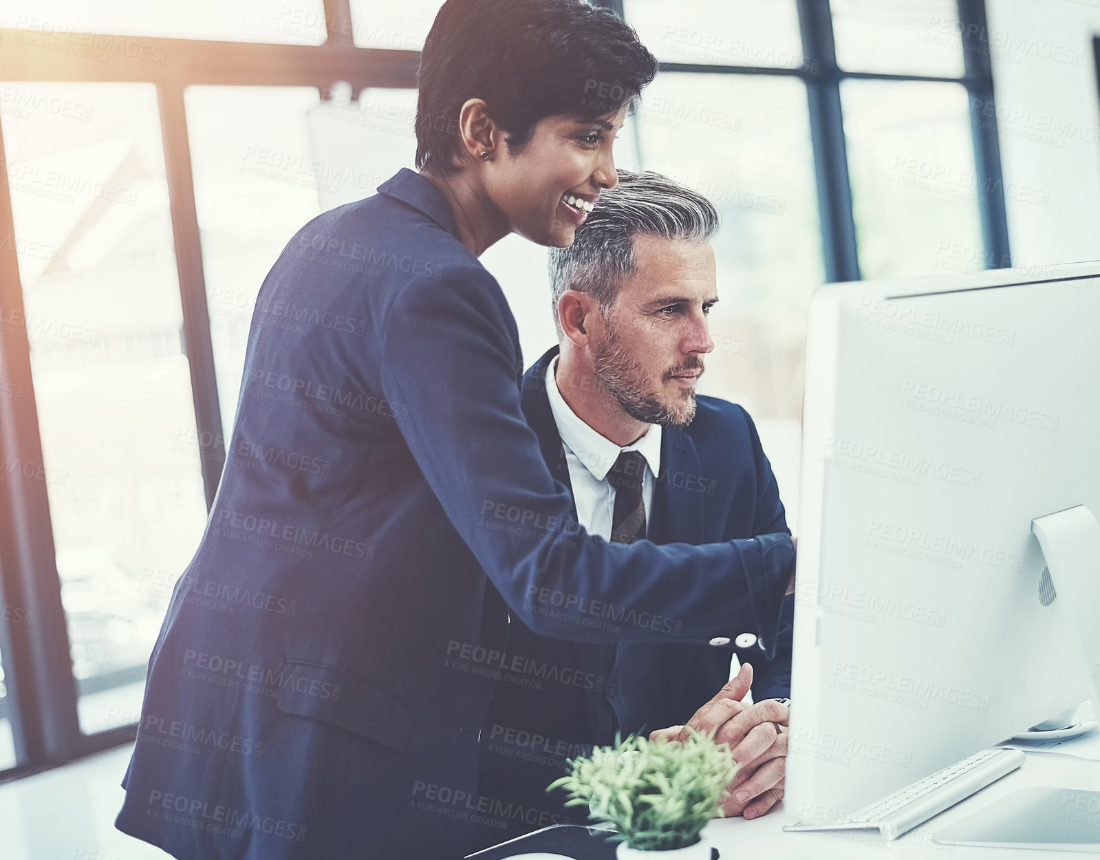 Buy stock photo Shot of a businesswoman and businessman using a computer together at work