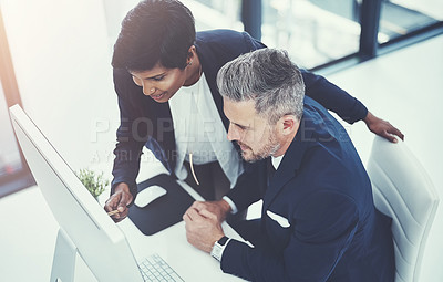 Buy stock photo Shot of a businesswoman and businessman using a computer together at work